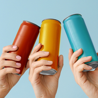 Three hands, each holding a different color beverage can, clicking the cans together.