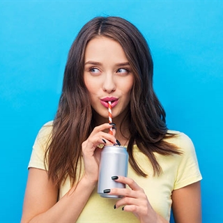 woman drinking from a can with a straw